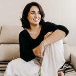 woman in black long sleeve shirt sitting on white couch